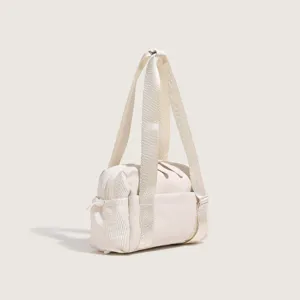 Detailed view of the off-white nylon gym bag, highlighting durable fabric and sturdy strap.