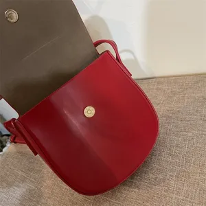 Detailansicht einer roten Umhängetasche mit Magnetverschluss, stilvolles Accessoire.