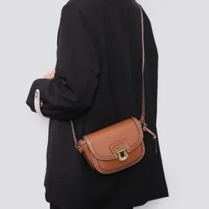 Detailed view of the stylish contrast stitching brown leather saddle bag, chic retro crossbody design.