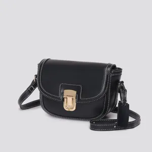 Close-up detail of the black leather saddle bag featuring contrast white stitching and gold lock.