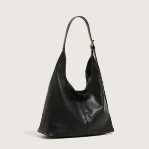 Detail view of the black minimalist leather hobo shoulder bag, showing texture and strap.