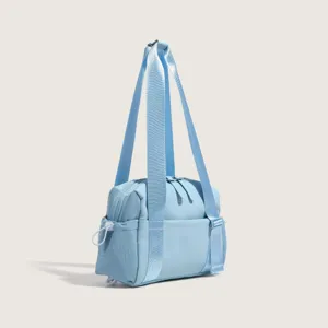 Detailed view of light blue nylon sports shoulder bag showing strap and zipper construction.