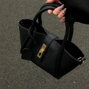 Black litchi grain leather handbag with gold lock clasp, stylish bucket tote for daily wear.