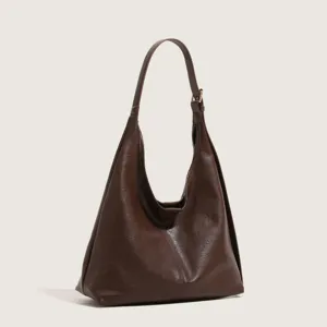 Close-up of brown faux leather hobo shoulder bag showing smooth texture and adjustable buckle.