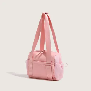 Pink nylon fitness shoulder bag detail view with long dual straps and secure zipper.