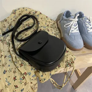 Detailaufnahme einer stilvollen schwarzen Ledertasche Umhängetasche mit schmalem Riemen.