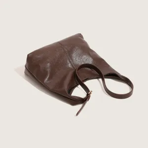 Dark brown leather hobo shoulder bag detail, minimalist casual design, smooth texture.
