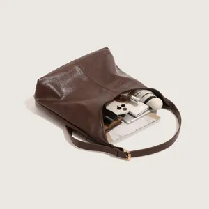 Detailed view of the dark brown leather bucket bag showcasing large capacity and daily essentials.
