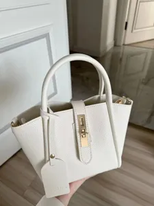 White pebbled leather tote bag with metal lock closure, stylish handbag for daily use.