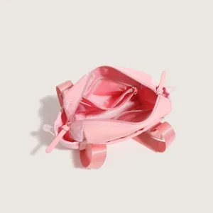 Detailed view of the pink nylon mini backpack, showing internal zipper compartments.