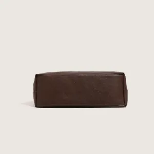 Brown leather handbag bottom detail shot showcasing material and stitching quality.