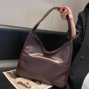 Detailansicht einer braunen weichen Leder-Schultertasche, zeigt Textur und Henkel.