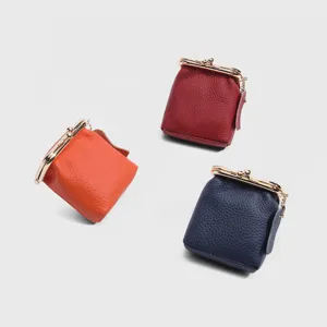 Detail view of mini genuine leather kiss lock coin purses in three colors with delicate metal frames.