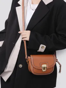 Stylish brown leather saddle bag for women, retro crossbody shoulder bag with metal lock.