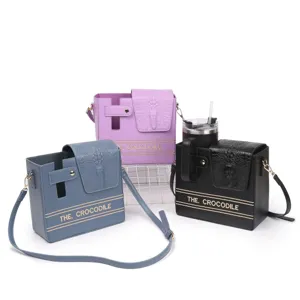Detailed view showing crocodile texture water bottle crossbody bag with fine hardware details.