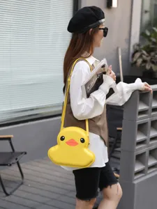 Cute yellow duck shoulder bag for women, cartoon hard shell crossbody bag for daily fashion wear.