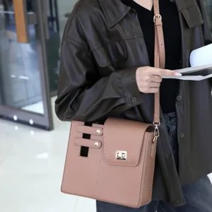 Detail view of the brown structured single shoulder crossbody bag with metallic lock closure.