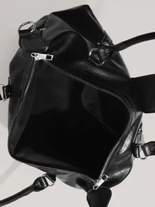 Detailed view of the black faux leather motorcycle handbag interior zipper and hardware.