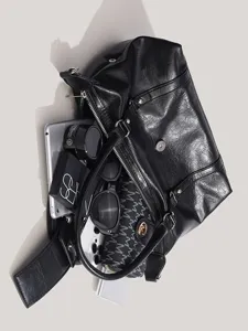 Black motorcycle shoulder bag detail showing spacious interior capacity and premium PU leather.