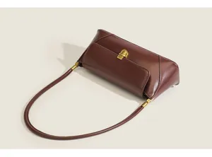 Retro brown leather shoulder bag detail view, stylish vintage baguette bag for women.