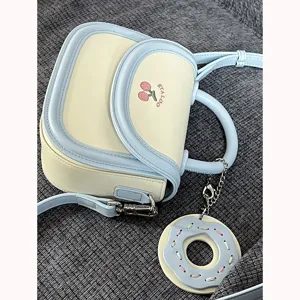 Borsa a sella bicolore in stile giapponese con ricamo di ciliegie e ciondolo ciambella.