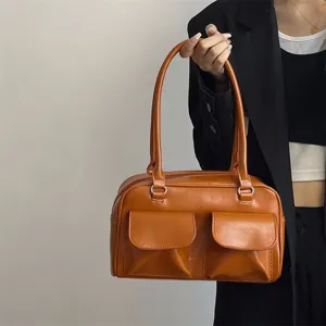 Brown vintage leather underarm shoulder bag with double front pockets for daily commute style.