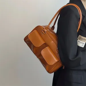 Detail view of the brown retro shoulder bag showing its front pocket and quality leather material.