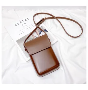 Detailed view of the vintage brown mini vertical crossbody phone bag styled on white fabric.