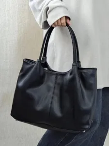 Close-up detail of black leather tote bag handle and texture, elegant minimalist style.