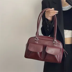 Burgundy leather shoulder bag detail, retro style with double front pockets and straps.