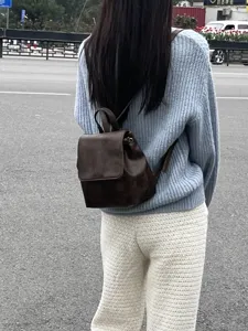 Vista dettagliata del mini zaino vintage marrone che mostra il design con patta e coulisse.