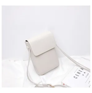 Detail view of a minimalist solid color vertical mini crossbody bag with fine strap.