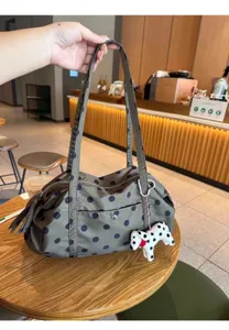 Detailed view of casual polka dot nylon shoulder bag in cafe scene with cute puppy charm.