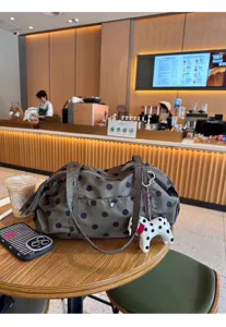 Large capacity polka dot nylon shoulder bag with cute plush puppy pendant for travel.