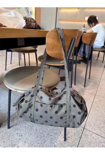 Detail view of casual nylon polka dot shoulder bag, large capacity travel tote design.