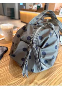 Close-up detail of stylish polka dot nylon duffel travel bag, featuring smooth zipper and durable fabric.