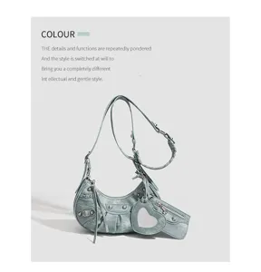 Detailed shot of light blue crescent shoulder bag featuring metal studs and heart mirror.