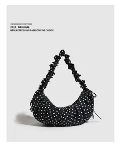 Black and white polka dot canvas shoulder bag detail, ruffled strap and drawstring design.