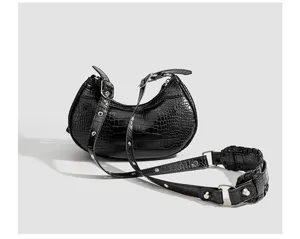 Black crocodile pattern crescent shoulder bag detail view with metal buckle and strap.