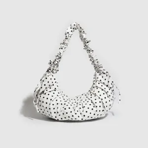 White black polka dot hobo bag with ruffled strap and drawstring design, perfect for daily use.