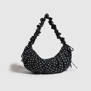 Black and white polka dot hobo dumpling bag with ruffled strap for women daily casual commute.