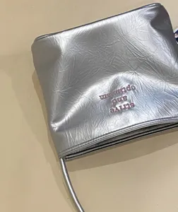 Silver metallic shoulder bag detail showing soft textured leather and stylish embroidered lettering.