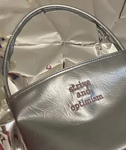 Silver metallic shoulder bag detail, trendy underarm handbag with chic letter embroidery for women.
