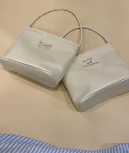 White leather shoulder bag with cute pink butterfly and letter embroidery for daily style.