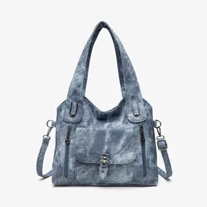 Detailed view of vintage washed denim tote bag featuring secure zippered pockets and buckle.