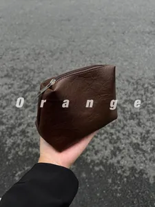 Brown leather cosmetic pouch detail shot, compact portable makeup storage bag for daily use.