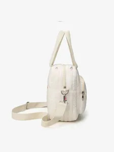 Detail view of the quilted shoulder bag featuring delicate pink tulip embroidery.