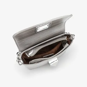 Detailed view of the silver chain crossbody bag showing multiple interior compartments and lock.