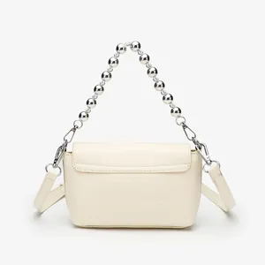Detailed view of the elegant cream white small square bag featuring metallic ball chain handle.