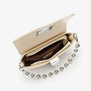 Detailed close-up view of women's beige PU leather shoulder bag with chic metal ball chain.
